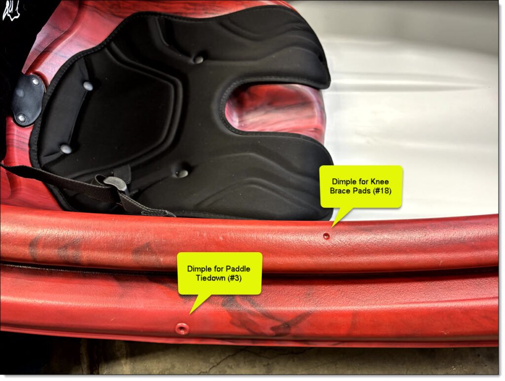 Showing the kayak's right cockpit edge with dimple marks for locating a knee brace pad and paddle tie down. 