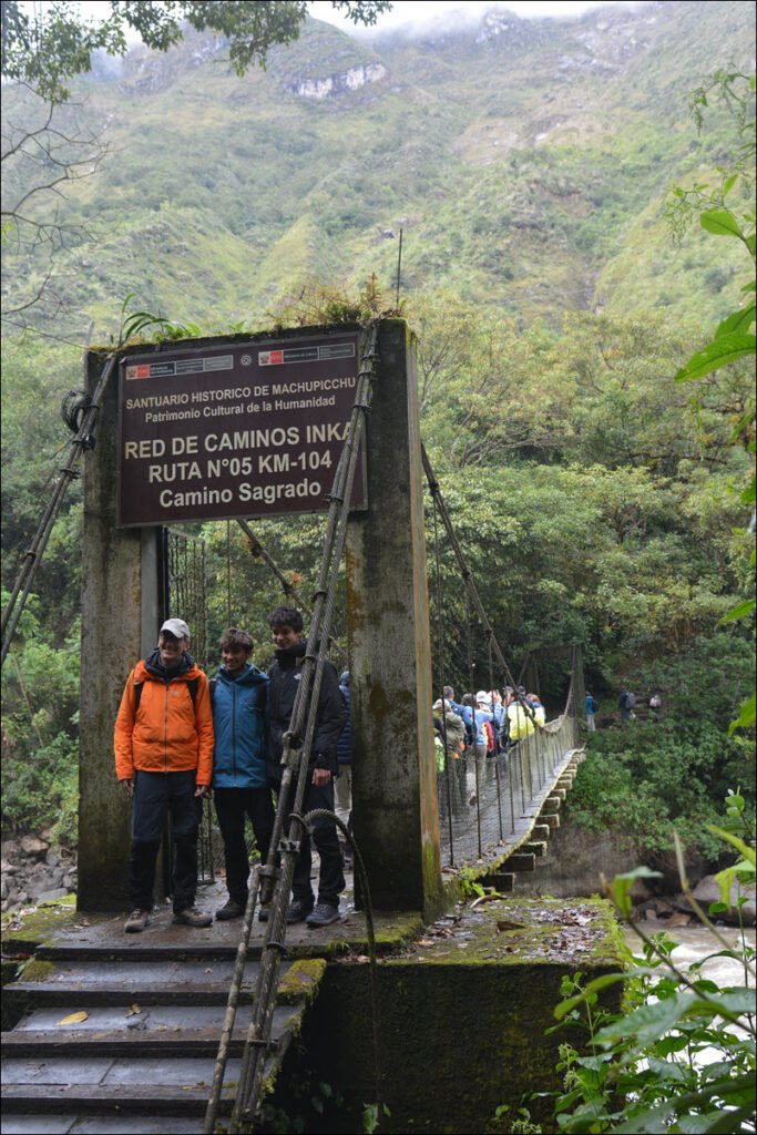 A walking Bridge Over The Urubamba River, Peru, at marker 104KM access to the Inca Trail between Cuzco and Machu Picchu, Peru. Our Adventure Begins