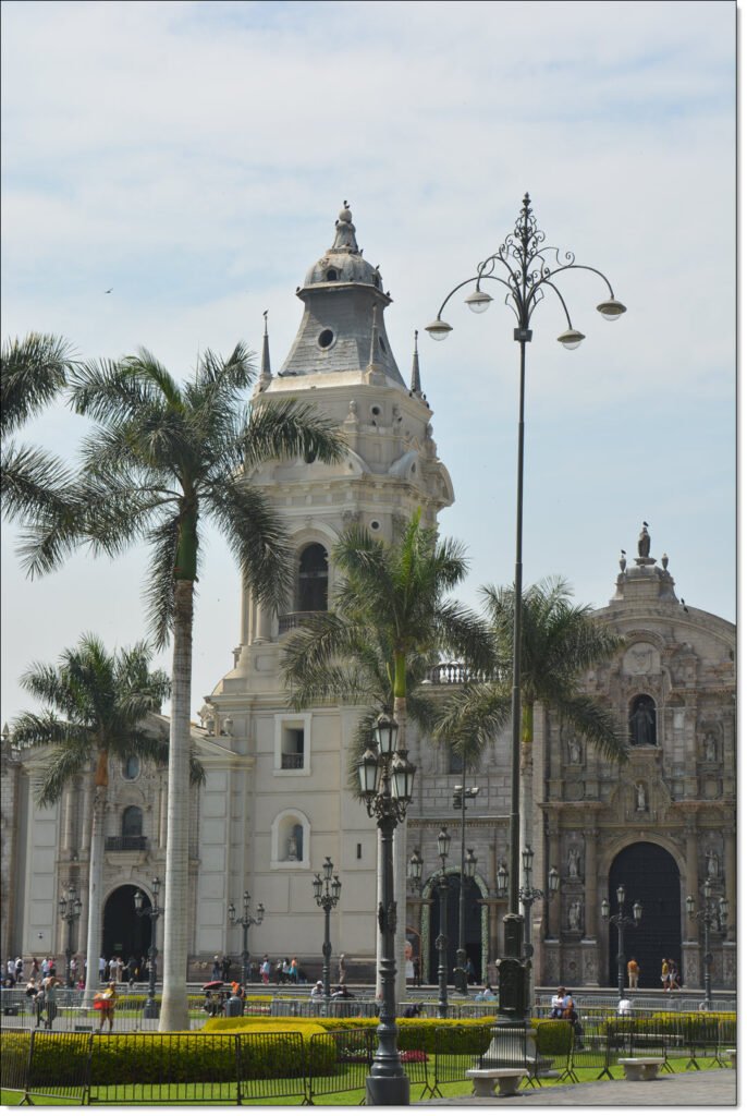 A large ornate cathedral with several palm trees in front.