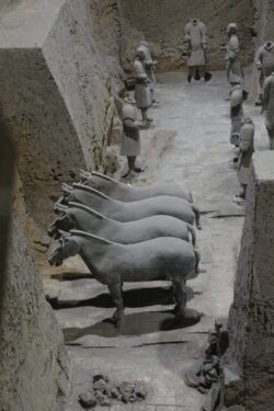 And the Horse You Rode in On excavated trench with a group of terracotta horses and a group of standing warriors.