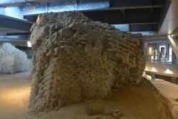 The Ancient Foundation of Leifeng Pagoda An ancient section of brickwork surrounded by a modern steel and glass structure.