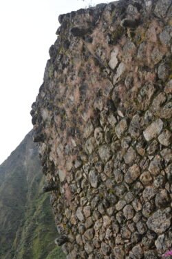 This is the remains of a house wall built in the sedimentary coursed masonry style, showing lintels needed for supporting roof poles. Located at the trailhead by "Marker 104KM" of the Inca Trail to Machu Picchu.