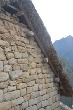 A detail of a reconstructed stone house in machu Picchu, showing how the stone lintels were used to support the roof poles.