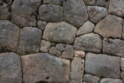 Detail of a stone wall built in the encased coursed masonry style.