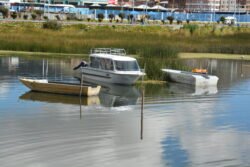 A trio of small boats moored in the harbor of Puno, on Lake Titicaca, Peru