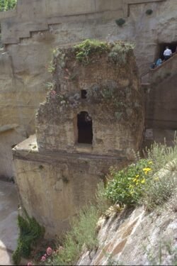 An ancient stone mausoleum on top of a stone structure