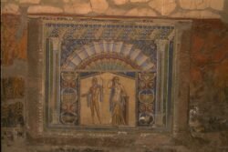 a roman mosaic of two people on a wall.