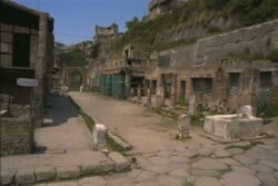 A cobblestone street lined with the ruins of ancient roman ancient Roman buildings.