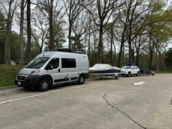 RV towing Bayliner 175BR named Sea Dragon, in front of a Jeep Cherokee towing a small trailer with two kayaks