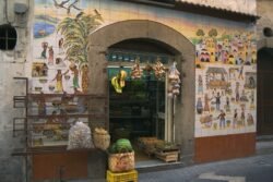 A ornate shop on a side street with wide arched entrance. The walls on both sides of the entrance are covered in highly ornamental tiles.