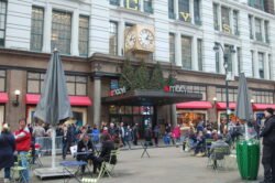 front entrance of macy's department store in new york, with several small tables set-up in the street in front