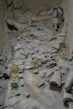 an open trench with the bottom littered with terracotta fragments