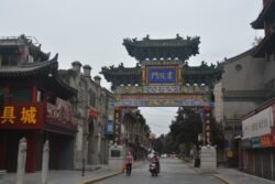 Shuyuanmen Street (Academy Gate) in Xi'an An ornate chinese-style gateway spanning a road lined with ships in traditional chinese style