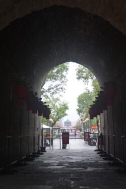 A View from Inside the Historical Xi'an City Wall Looking through a tunnel with a Chinese-style building in the distance