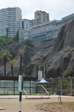 Looking up the coastal cliffs from the beach with the shopping mall of Parque Salazar, Miraflores District, at the top.