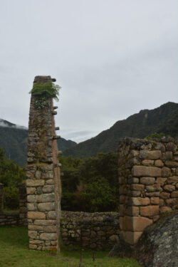 A side view of a small stone house, showing the lintels of the roof area. These lintels were used to support wooden poles for the roof, which were then covered with thatch for waterproofing. Located at the trailhead by "Marker 104KM" of the Inca Trail.