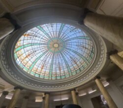 A large stunning stained glass cupola backlit with the afternoon sun.