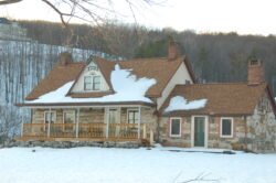 A stone house with red shingle roof, partially covered with snow.  Burlingham, New York