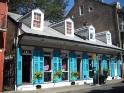 a row of narrow turquoise-colored townhouses in the French Quarter of New Orleans