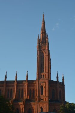a view of a brick cathedral with a soaring steeple.