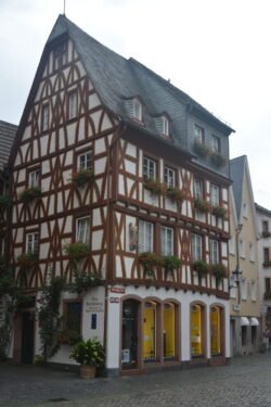 a half-timbered house of whitewashed stucco between exposed dark wood timber framing.