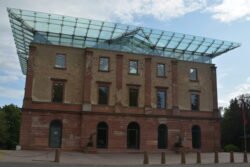 a neoclassical brick building capped with a modern-style glass roof.
