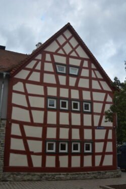 a half-timbered house of dark wood beams framing patterns of whitewashed stucco