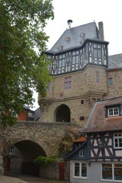 a castle built of stone on the lower section, with a half-timbered upper section and slate roof