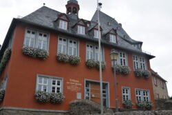 a large red building with large double windows and slate roof