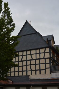 facing one wall of a half-timbered house with whitewashed stucco walls and dark wood timbers