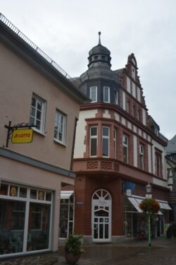 a stone and half-timbered building with decorative round turret roof