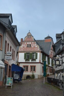 looking down a cobblestone road with half-timbered buildings on each side, facing another half-timbered house at the end of the street