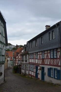 Looking down a cobblestone street lined with 16th-centurt half-timbered buildings
