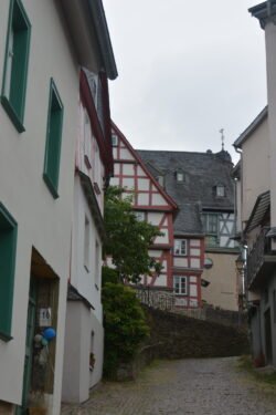 a cobblestone dead-end street with a half-timbered house at the end