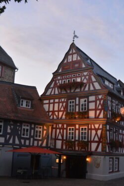 a large half-timbered building illuminated from lights along the street