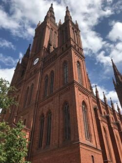 dramatic view looking straight up at a brick cathedral with twin steeples.