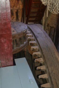 large wooden gears converting vertical motion to horizontal motion