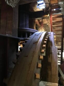 large wooden gears converting vertical motion to horizontal motion